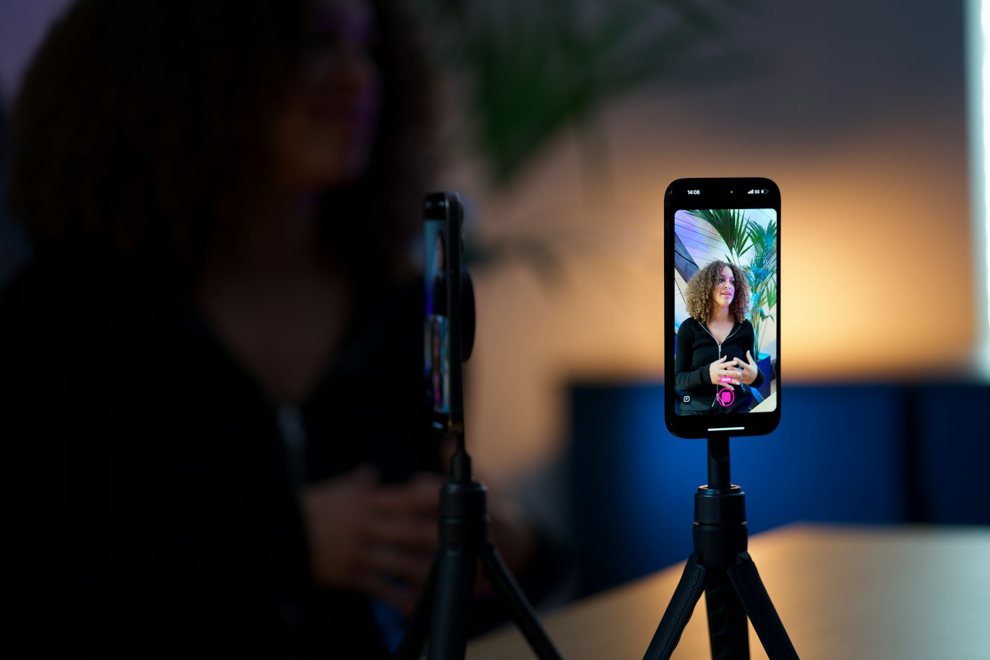 Smartphone on a tripod recording a woman presenting for video.